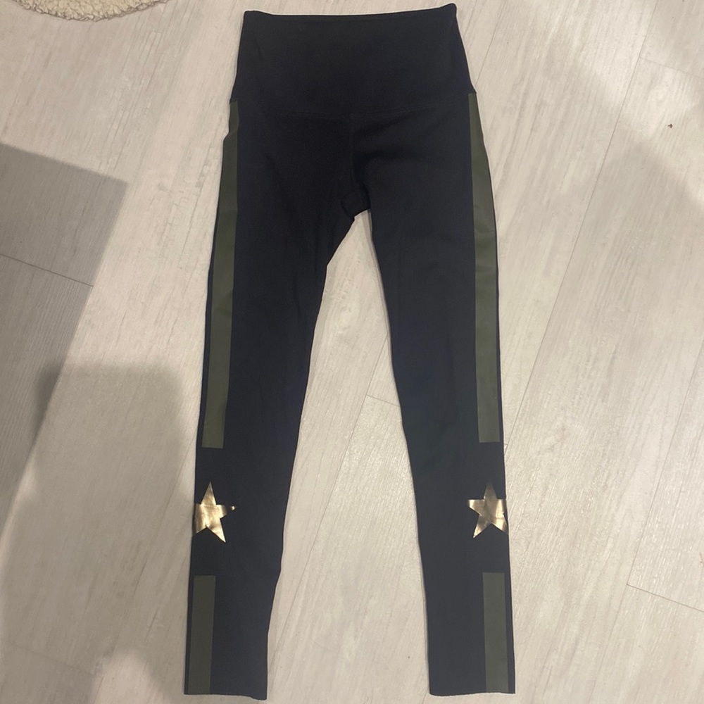 These are black leggings with a green streak and a star on both sides